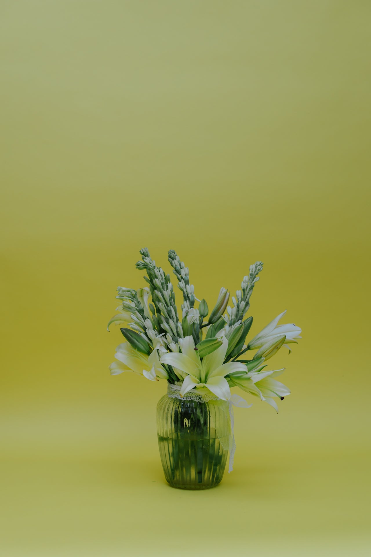 Ivory Fushion in Vase: Lilies and Rajnigandha