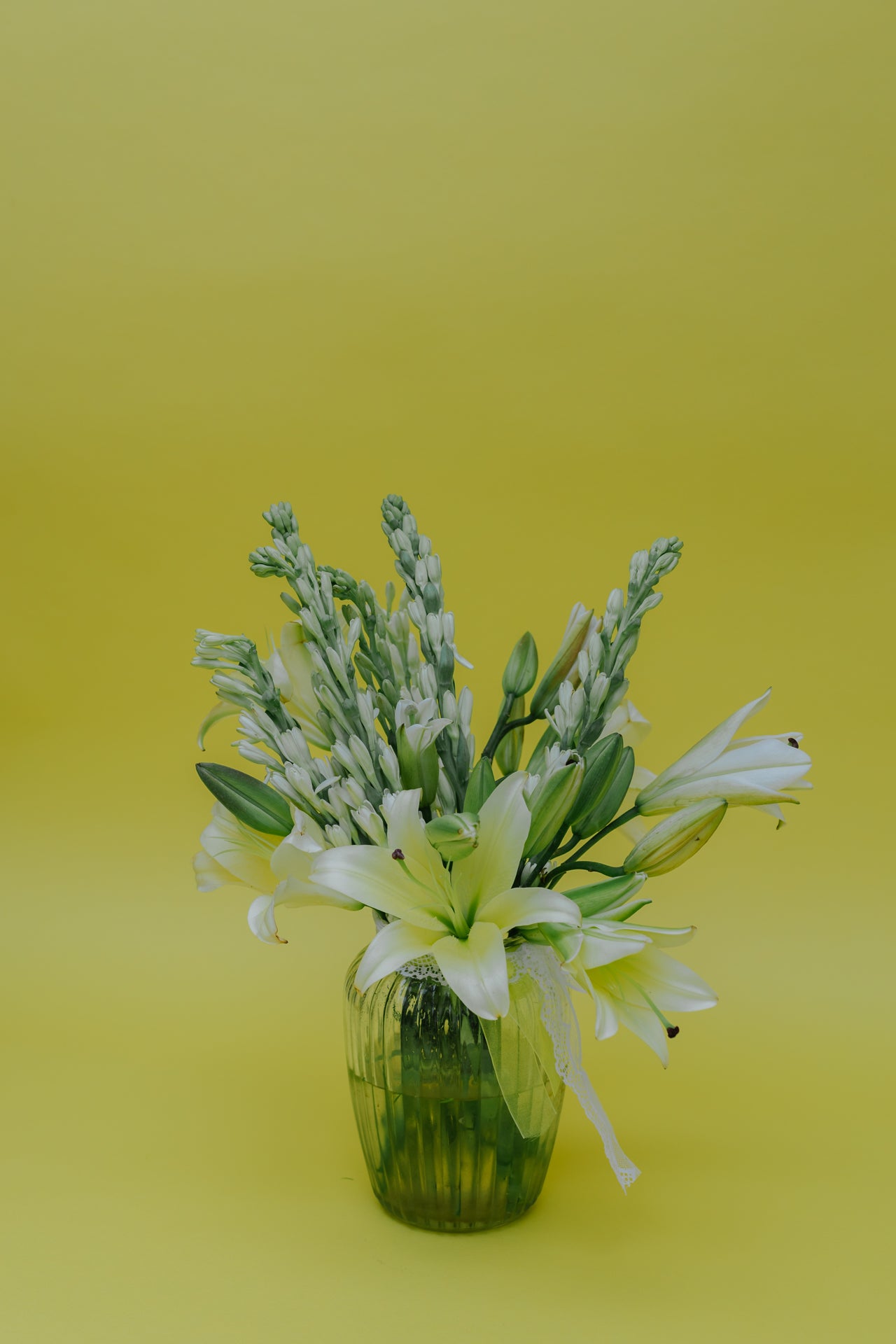 Ivory Fushion in Vase: Lilies and Rajnigandha