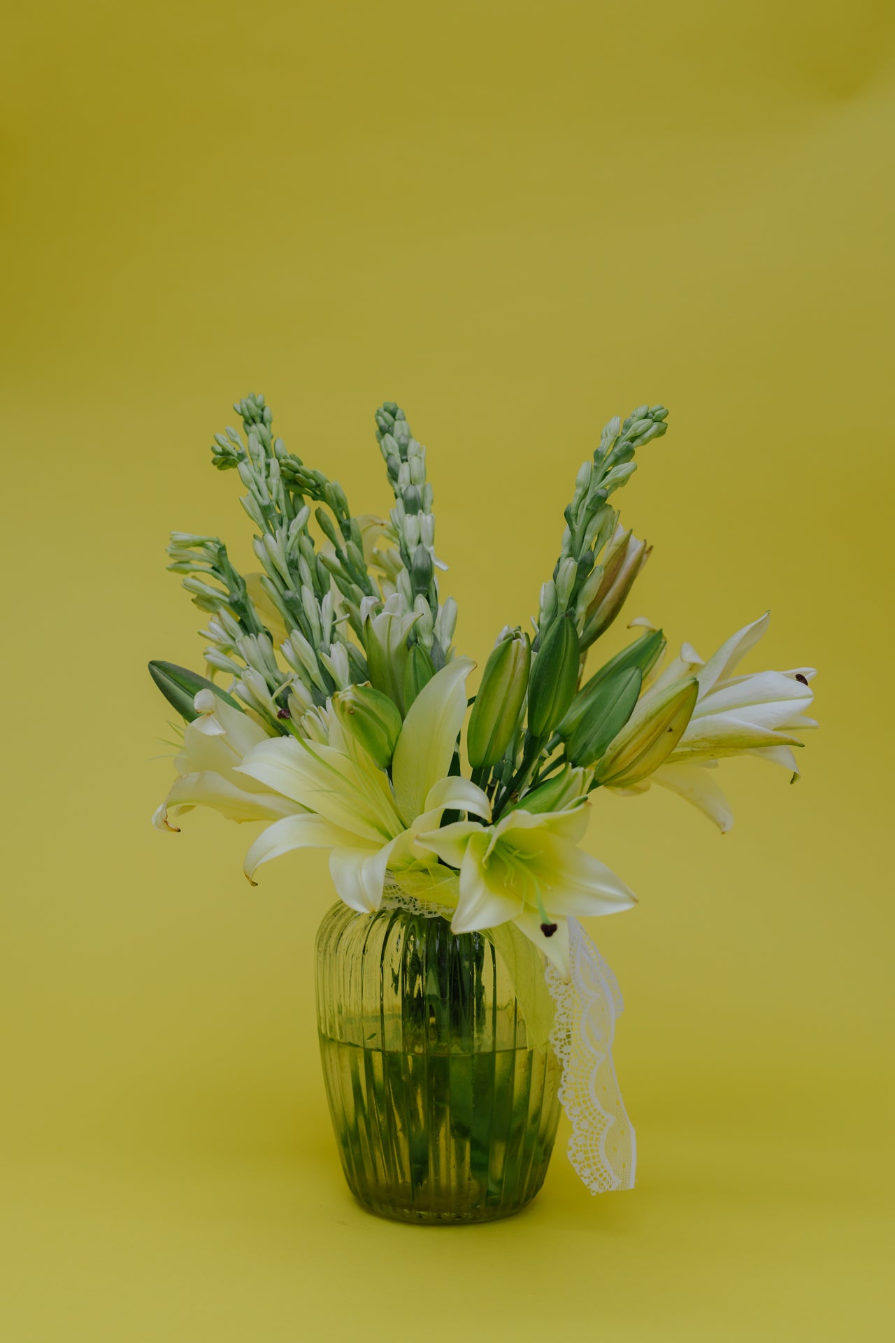 Ivory Fushion in Vase: Lilies and Rajnigandha